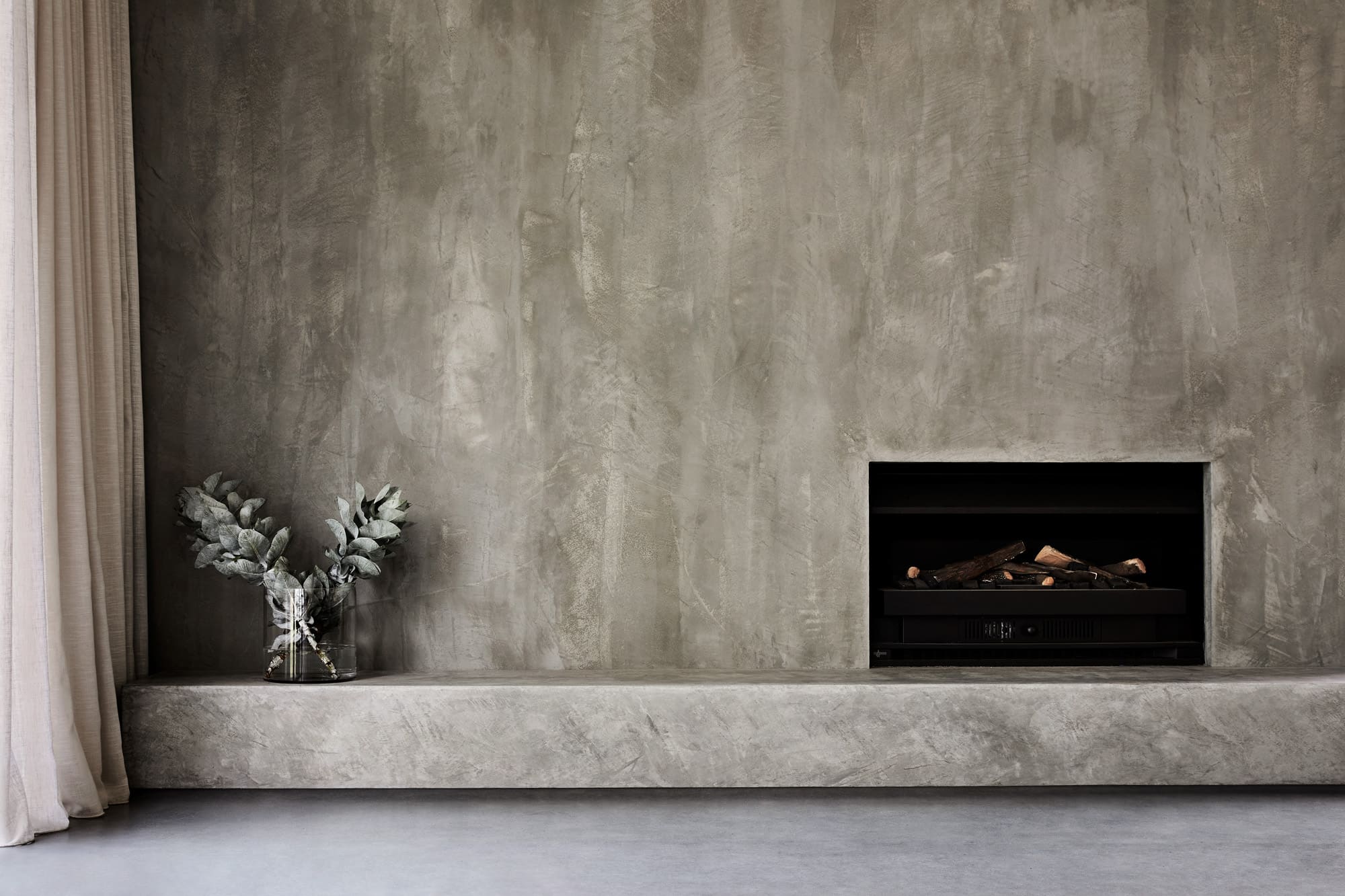 Interior shot of fireplace and grey wall